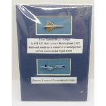 A silver Concorde pin badge and a similar enamel badge, mounted on card