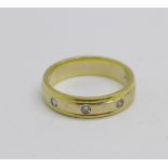 An 18ct gold and three stone diamond wedding band, 0.25ct diamond weight, 3.6g, I