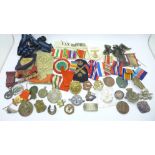 Military cap badges, uniform patches, ribbons, an enamelled Royal Navy brooch, lacking hook, a
