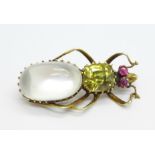 A yellow metal set beetle brooch, with an oval moonstone, yellow stone and two ruby eyes, 36mm, (