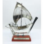 A silver model of a Dhow on a wooden stand, 88g, 15.5cm