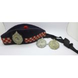 A Scottish Glengarry cap with Argyll and Sutherland badge and two other Argyll and Sutherland badges