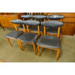 A set of six teak and black vinyl dining chairs