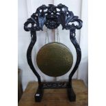 A Chinese brass gong on carved ebonised stand