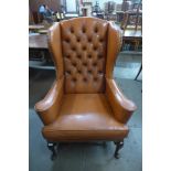 A George III style mahogany and leather wingback armchair