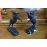 A pair of French style bronze boxing hares, on black socles, 30cms h