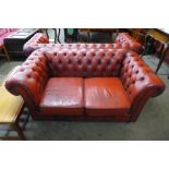 A red leather Chesterfield settee