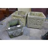 A pair of concrete garden planters and another