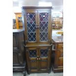 A carved oak linenfold freestanding corner cabinet