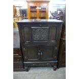 A carved oak cocktail cabinet