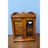 An Edward VII carved oak smokers cabinet