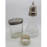 A silver topped sugar castor, a silver topped dressing table jar and a silver napkin ring