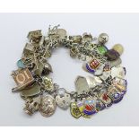 A silver bracelet with a collection of mainly silver charms including emergency 10 shillings note,