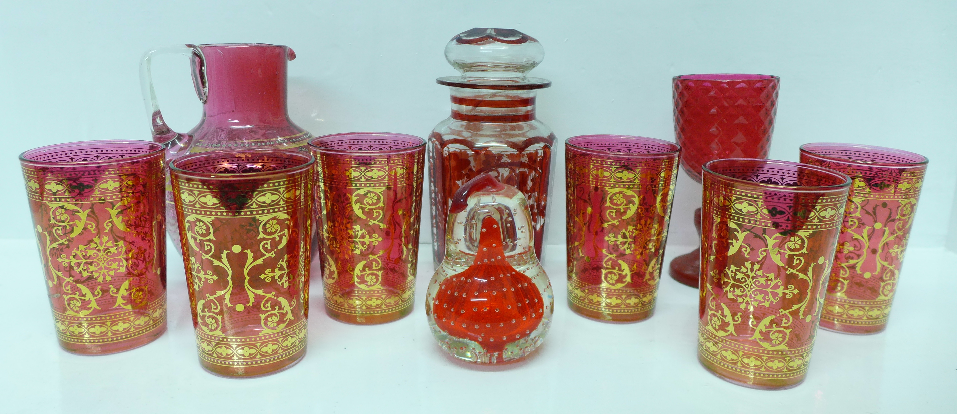 Six Italian glass beakers with gilt decoration, a cranberry glass jug, a glass jar, lid a/f, a glass