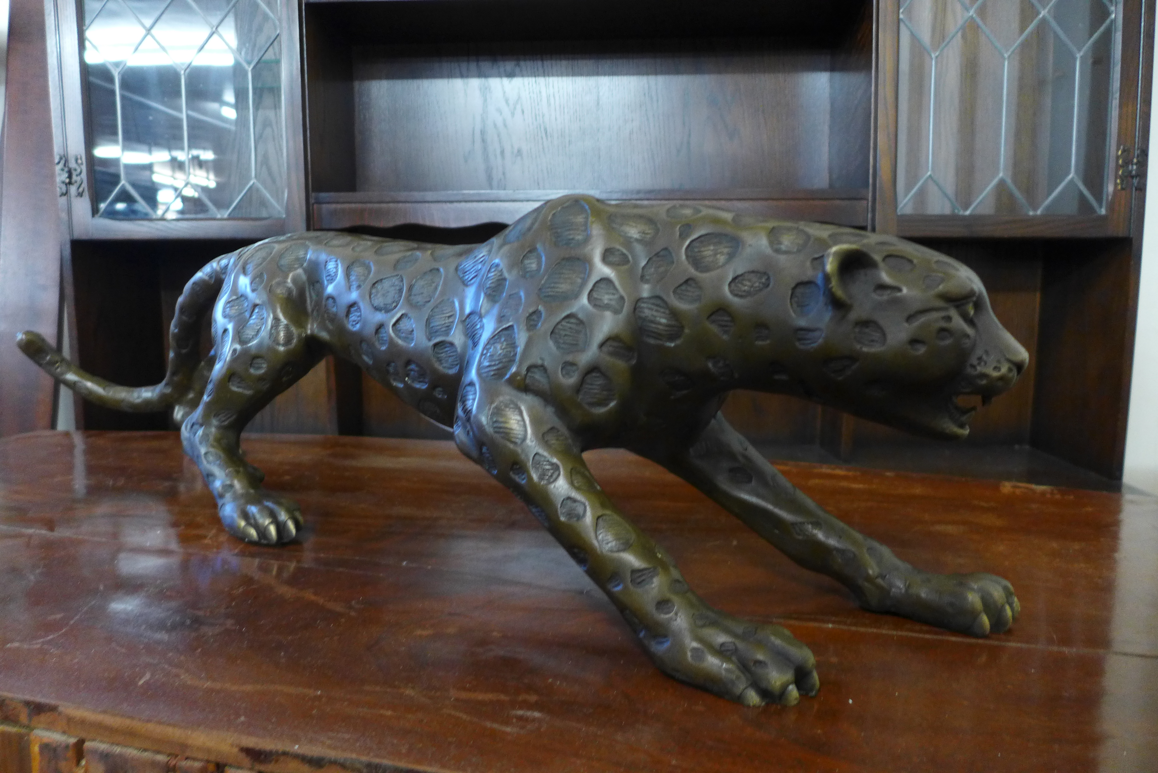 A bronze figure of a crouching leopard, 21cms h x 79cms l