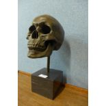 A bronze skull, on black marble socle, 36cms h