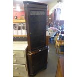 An oak freestanding corner cabinet