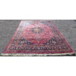 An eastern geometric patterned red ground rug, 341 x 250cms