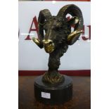 A French style bronze rams head, on black marble socle, 43cms h