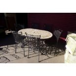 A wrought steel garden table with mosaic top and six chairs