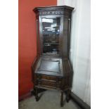 An early 20th Century Jacobean Revival carved oak freestanding corner bureau bookcase, 203cms h,