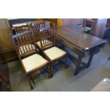 An Old Charm carved oak x-frame drop-leaf table and four spindle back chairs