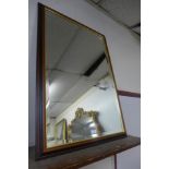 A mahogany and parcel gilt framed bevelled mirror