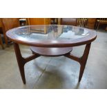 A teak and glass topped circular coffee table