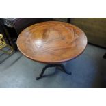 An oak and leather circular topped tripod table