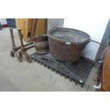 A copper cooking pot, brass coal scuttle, andirons and a fire grate