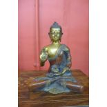 An oriental bronze figure of a seated deity, 19cms h