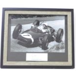 A black and white photograph of Sir Stirling Moss at the 1961 German Grand Prix with mounted