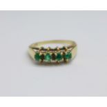 A 9ct gold and four stone emerald ring, 3g, S