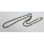 A cultured black pearl necklace, the clasp marked 750, 56cm