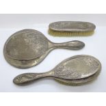 A silver hand mirror and two silver backed brushes with butterfly decoration, mirror a/f