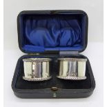 A pair of silver napkin rings, cased, 64g