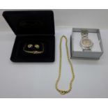 A gold coloured necklace and earring set and a Spirit wristwatch