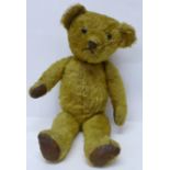 An American Teddy bear, circa 1940's with jointed limbs, glass eyes and smooth Rexene pads, 52cm