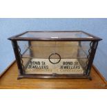 An oak counter top shop cabinet, bearing Asprey, Bond St. Jewellers, London inscription, 27cms h x