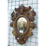 A small 19th Century Italian rococo revival carved giltwood framed engraved mirror, 43cms h