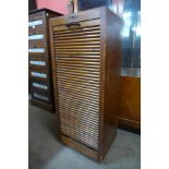 An early 20th Century Simpole S oak tambour front filing cabinet, 116cms h x 48cms w