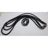 An extra long black glass bead three strand necklace with paste clasp and matching bracelet