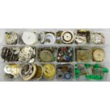 A collection of watch movements and dials and other watch parts