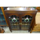 An Art Nouveau oak and stained glass two door bookcase
