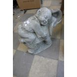 A concrete garden figure of a child and elephant