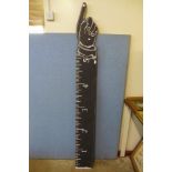 A painted wooden measuring stick/sign