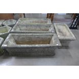 A set of three concrete garden planters and one other.