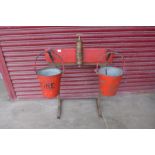 A vintage fire extinguisher and two fire buckets on stand