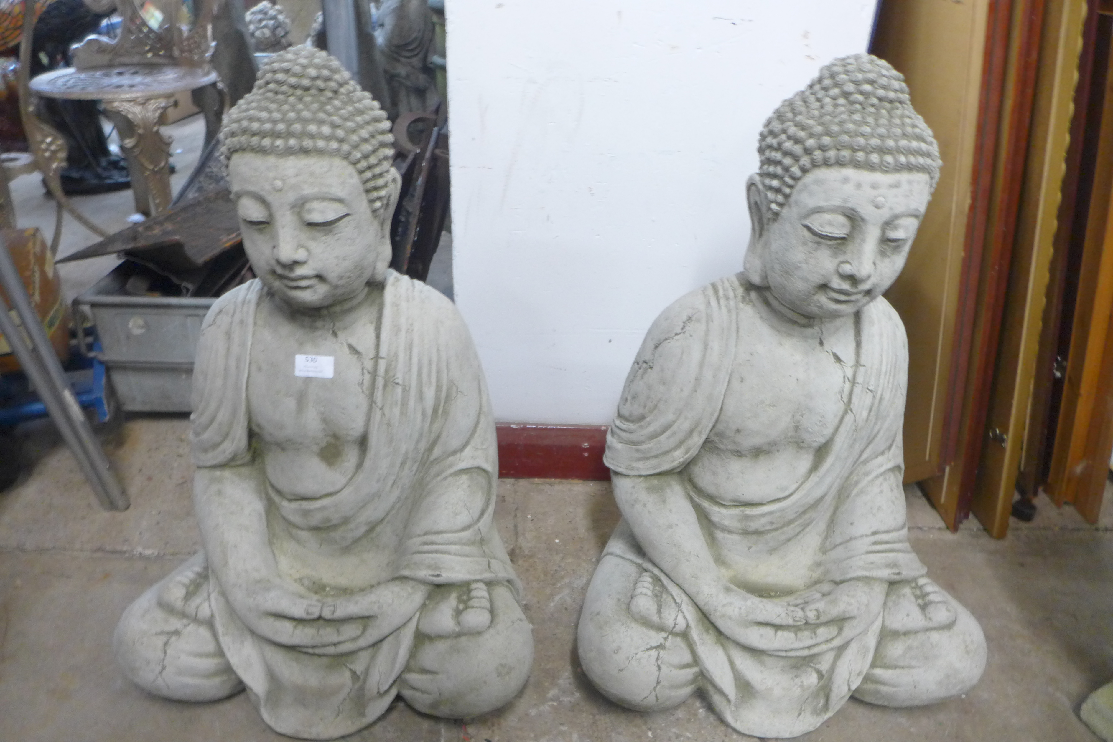 A pair of concrete garden figures of a seated deities, 69cm h