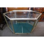 A metal and glass hexagonal shop cabinet, 89cms h, 130cms w, 64cms d